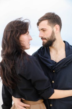 Birbirlerine sarılma ve tek sesli kış arka planda moda giysiler giyen genç Avrupa çift. Moda ve romantik aşk kavramı.