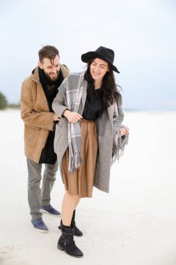 Mutlu beyaz kadın ve kat ve kış kar arka planda duran tulum giyen adam.