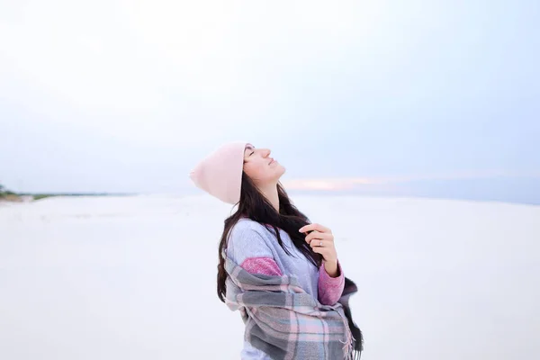 年轻的欧洲女孩穿着毛衣 围巾和帽子站在白色的冬季背景 季节性灵感和照片会议的概念 — 图库照片