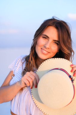 Gülümseyen kadın şapka mavi tek sesli arka planda tutmak.