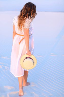 Arkadan Görünüş duran genç kadının üzerinde beyaz mavi kum.