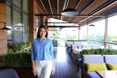 Kafkas kadın smartpone, sokak kafe ayakta kot gömlek giymiş.