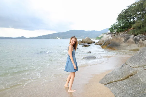 Молодая блондинка ходит босиком по песку, утренний берег моря . — стоковое фото