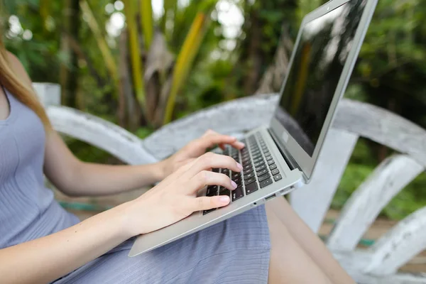Mujer caucásica persona usando el ordenador portátil, palmas en el fondo . — Foto de Stock