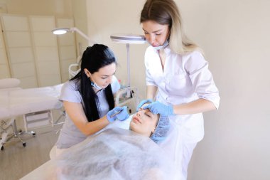 Esmer güzellik uzmanı ve hemşire eybrows dövme.
