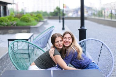 Güzel kadınlar dışında kafede oturan.