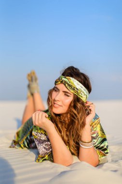 Beyaz yalan yeşil plaj elbise giyen genç iyi görünümlü kadın