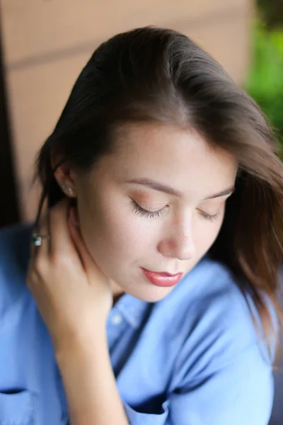 Nahaufnahme Gesicht der schönen jungen Frau mit alltäglichem Make-up, trägt Jeans-Shirt. — Stockfoto