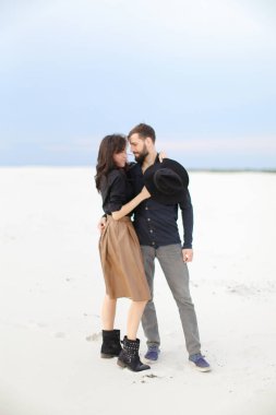 Genç çift etek ve siyah gömlek giyen kış kar tek sesli arka planda, sarılma.