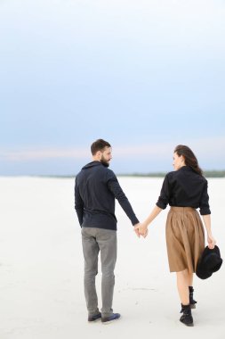 Kadın ve etek ve şapkalı, arka plan siyah gömlek giyen adam karda yürüme ve elele,.