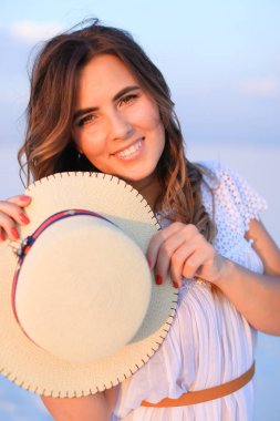 Kız şapka mavi tek sesli arka planda tutmak gülümseyen.