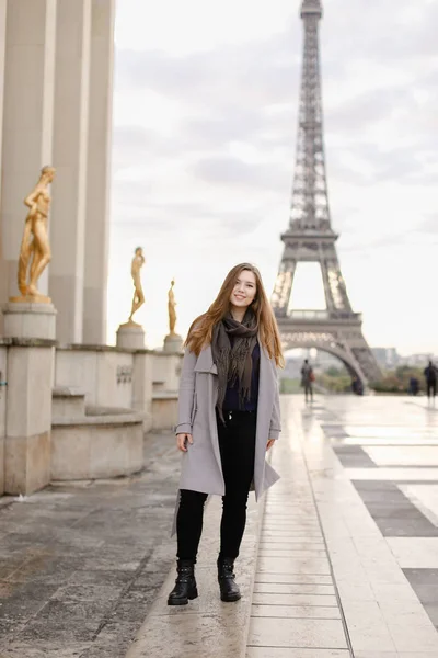 Młoda kaukaski kobieta stojąc na placu Trocadero, niedaleko złoconych posągów i Wieża Eiffla. — Zdjęcie stockowe
