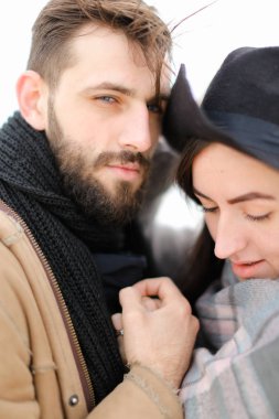 Atkı ve şapka giyen kadın sarılma adam portresi kapatın.