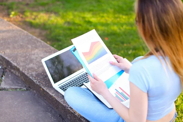 Estudiante trabajando con laptop y diagramas al aire libre . — Foto de Stock