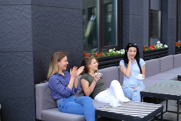 Bonitas amigas riéndose de la cafetería y chismorreando, bebiendo café . — Foto de Stock