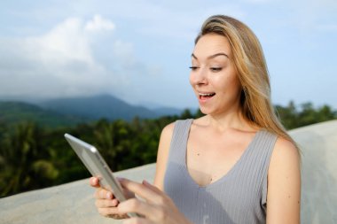 Genç Amerikalı kadın tablet Dağları arka planda kullanma.
