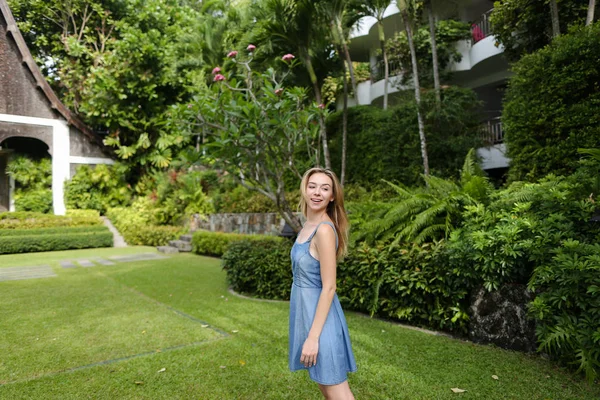 Jong meisje permanent op groen gras in de buurt van resort huis. — Stockfoto