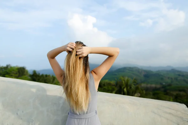 Молодая расслабленная девушка, стоящая на фоне гор . — стоковое фото