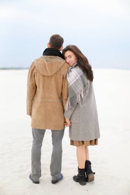 Genç çift kat ve tulum giyen kış kar arka planda, yürüyüş.