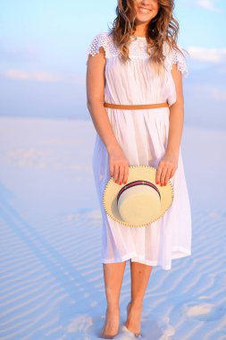 Elbise giyen ve b kum üzerinde ayakta tutmak şapka, Genç kadın