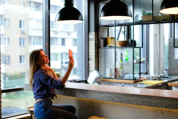 Charmantes Mädchen macht Selfie mit dem Smartphone in der Café-Bar. — Stockfoto