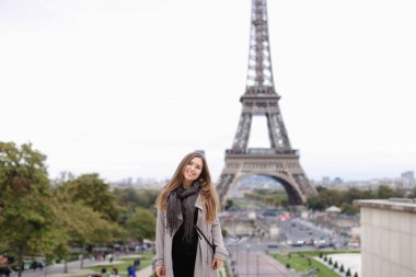 Güzel kadınla Paris'te Eyfel Kulesi arka plan gri ceket ayakta.