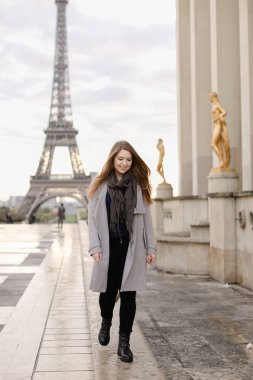 Trocadero Meydanı yaldızlı heykeller ve Eyfel Kulesi yakınında duran genç güzel kadın.