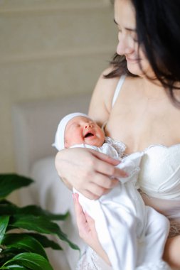 Yeni doğan bebek tutan anne giyen beyaz elbise genç güzel.