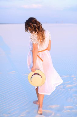 Arkadan Görünüş kafkas kadın beyaz mavi kum üzerinde duran.
