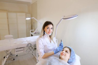 Genç kadın makyaj güzellik uzmanı tarafından kaş dövme kalemi tarafından elde.