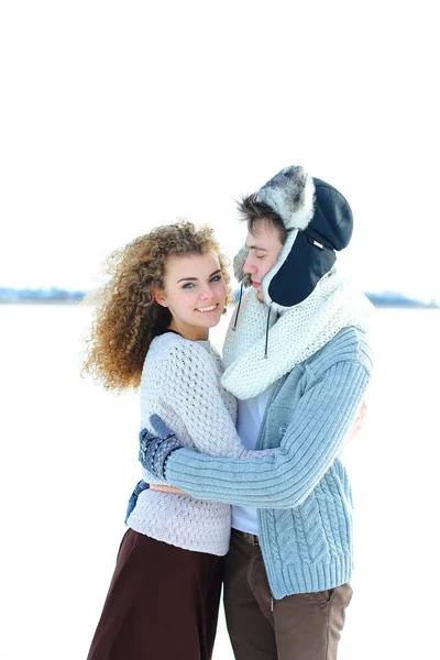 Mulher abraçando menino vestindo chapéu de inverno e luvas no fundo de inverno . — Fotografia de Stock