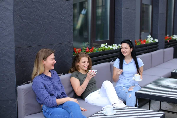 Mujeres amigas positivas riéndose de la cafetería y chismorreando, bebiendo café . — Foto de Stock