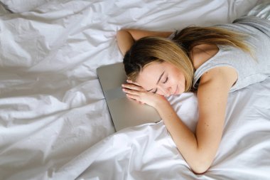 Sabah dizüstü yatakta yatan genç kadın.