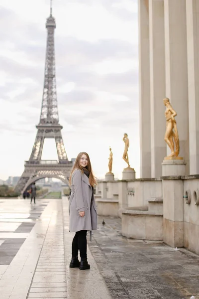 Caucasian woman standing on Trocadero square near gilded statues and Eiffel Tower. — Stock Photo, Image