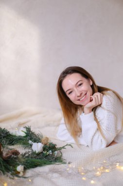 Genç Amerikalı kadın yatakta yeşil çelenk ve sarı çelenk yakın yalan.