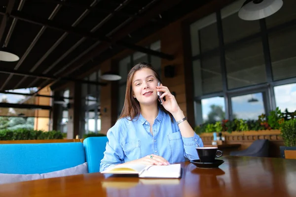 Mujer de negocios descansando en la cafetería con portátil y taza de café, hablando por teléfono inteligente . — Foto de Stock