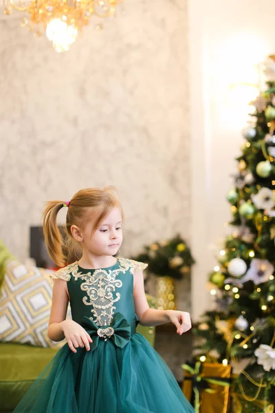 Kleines Mädchen trägt Kleid und steht mit Bengalischen Lichtern am Weihnachtsbaum. — Stockfoto