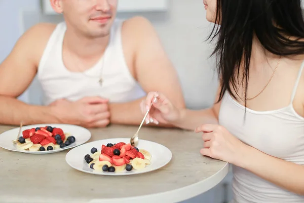 夫とお粥と漿果を持つ 2 つのプレート、キッチンで朝食をとり妻. — ストック写真