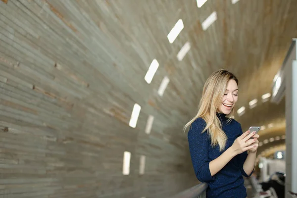 Mujer bonita charlando por teléfono inteligente moderno en fondo monótono . — Foto de Stock