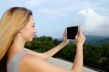 Tablet ve çekici fotoğraf Dağları arka planda kullanan genç Amerikalı kadın kişi.