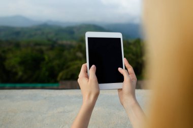 Modern tablet Dağları arka planda kullanan kadın kişi.