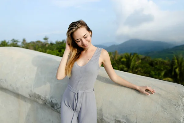 Молодая расслабленная женщина стоит на фоне гор . — стоковое фото