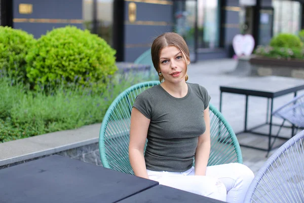 Mulher bonita descansando no café de rua e sentado perto de planta verde . — Fotografia de Stock