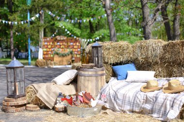 Şapkalar ve şişe buğday kulaklı yakınındaki saman yastıklar.