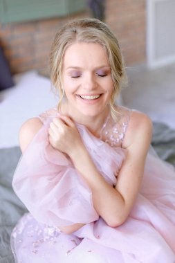 Oturma odasında ve gülümseyen mutlu güzel sarışın gelin.