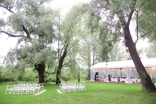 Sillas blancas y tierno arh de flores para boda en el parque . — Foto de Stock