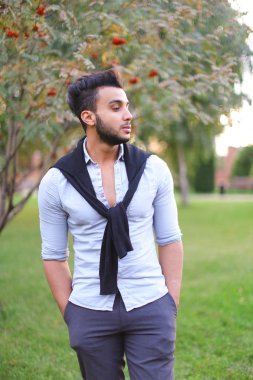 Genç adam parkta yürüyor..