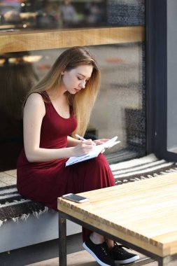 Genç öğrenci yazılı defter Üniversitesi'nde, tablo smartphone olarak.