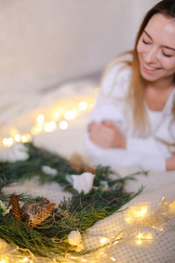 Pozitif kadın yatakta yeşil çelenk ve sarı çelenk yakın yalan.