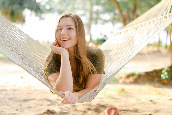 Menina bonito jovem deitado na rede de vime branco e vestindo vestido cáqui . — Fotografia de Stock